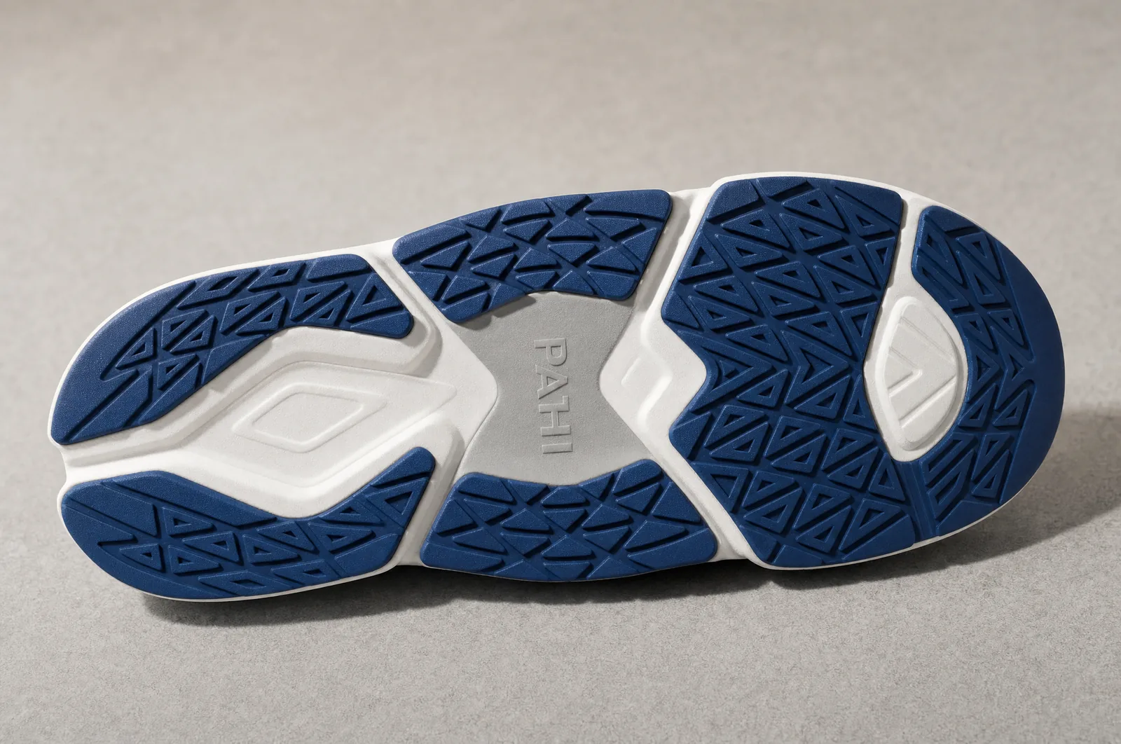 The tread pattern close, raking light so the pattern reads as depth rather than as a drawing. Dry surface. Never a wet floor, never a shower, never a bathroom: the ASTM result is a bench test and the frame must not imply a use case it does not cover.